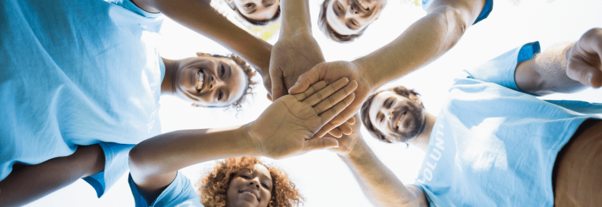 a group of people putting their hands together