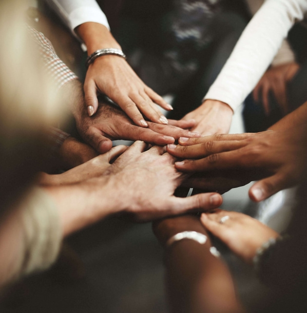 a group of people putting their hands together